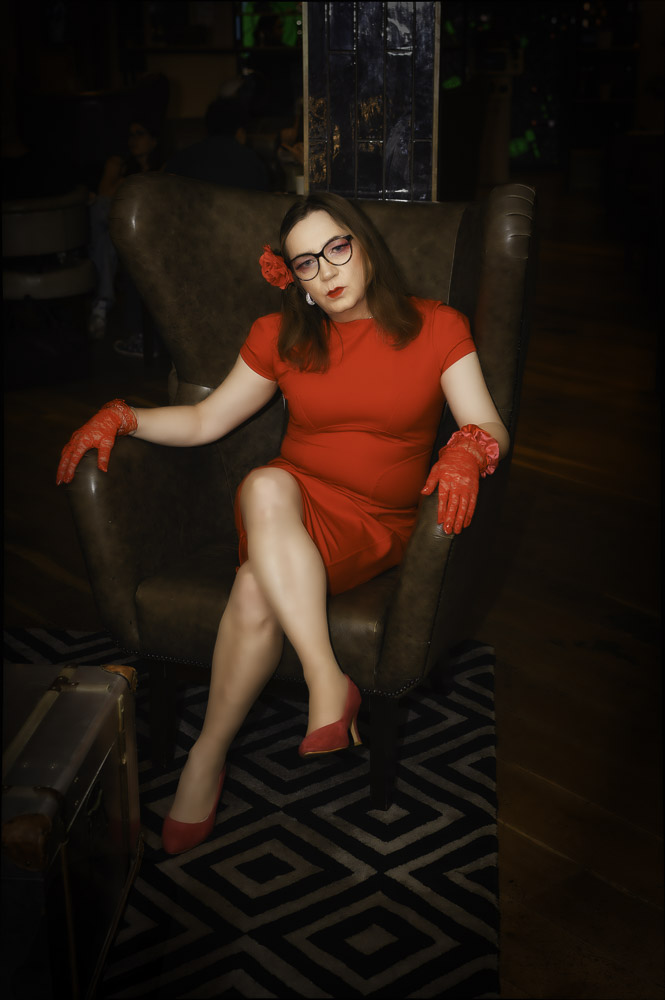 Annabelle in a red dress, seated at the hotel, getting ready for the evening