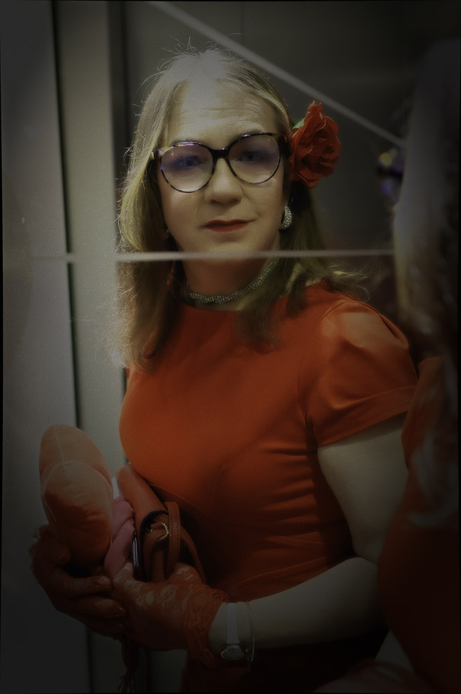 Annabelle in a red dress, reflected in the hotel lift doors