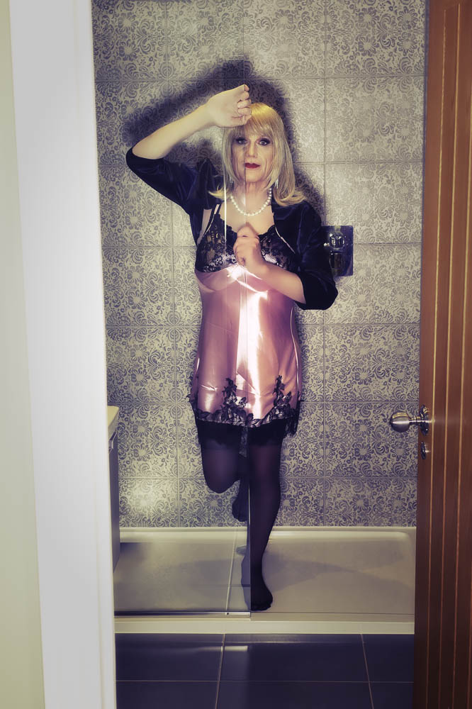 Daniella in a pink chemise in the bathroom
