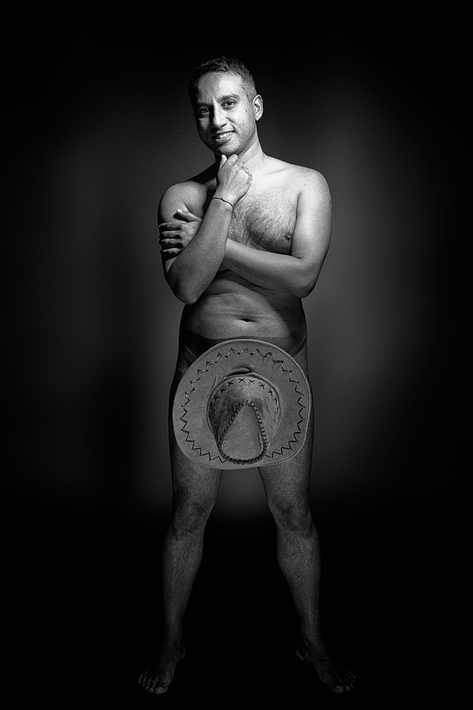 Naked male with genials hidden behind hat