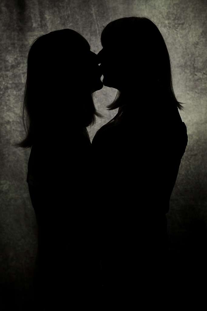 Silhouette of Nia and Sandra facing each other, kissing
