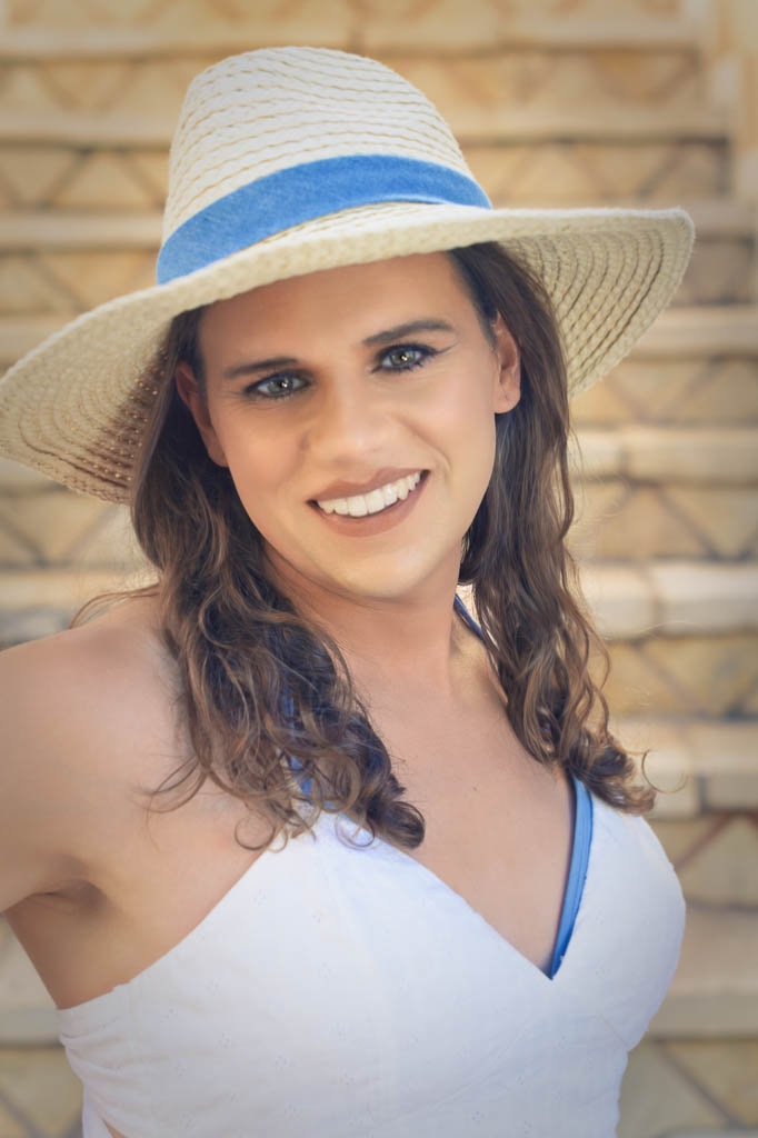 Headshot of Jessica in a white sun dress and sunhat, on the steps, Zakynthos