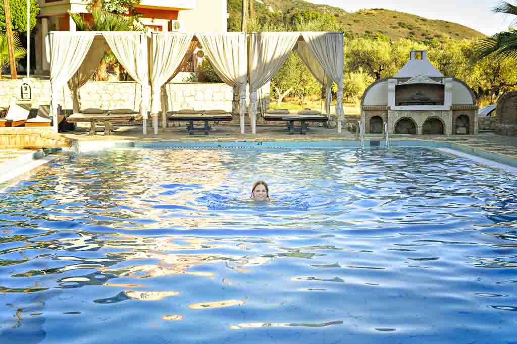 Wide angle shot of Jessica swimming in an orange bikini, Zakynthos