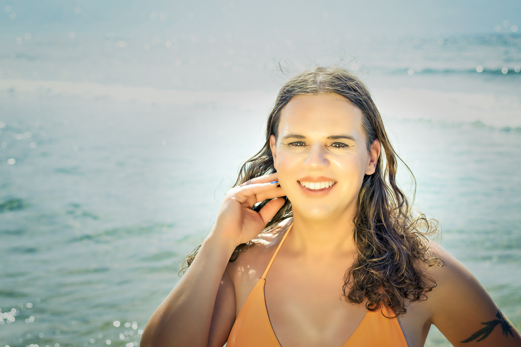Headshot of Jessica in an orange bikini, sea behind her, no sunglasses, Gerakas Beach, Zakynthos